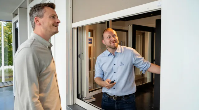 verkoper geeft uitleg over screens aan een klant in de showroom